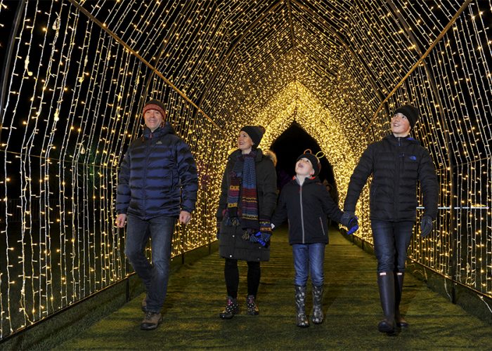 Family walking through illuminated arch at Malvern Winter Glow